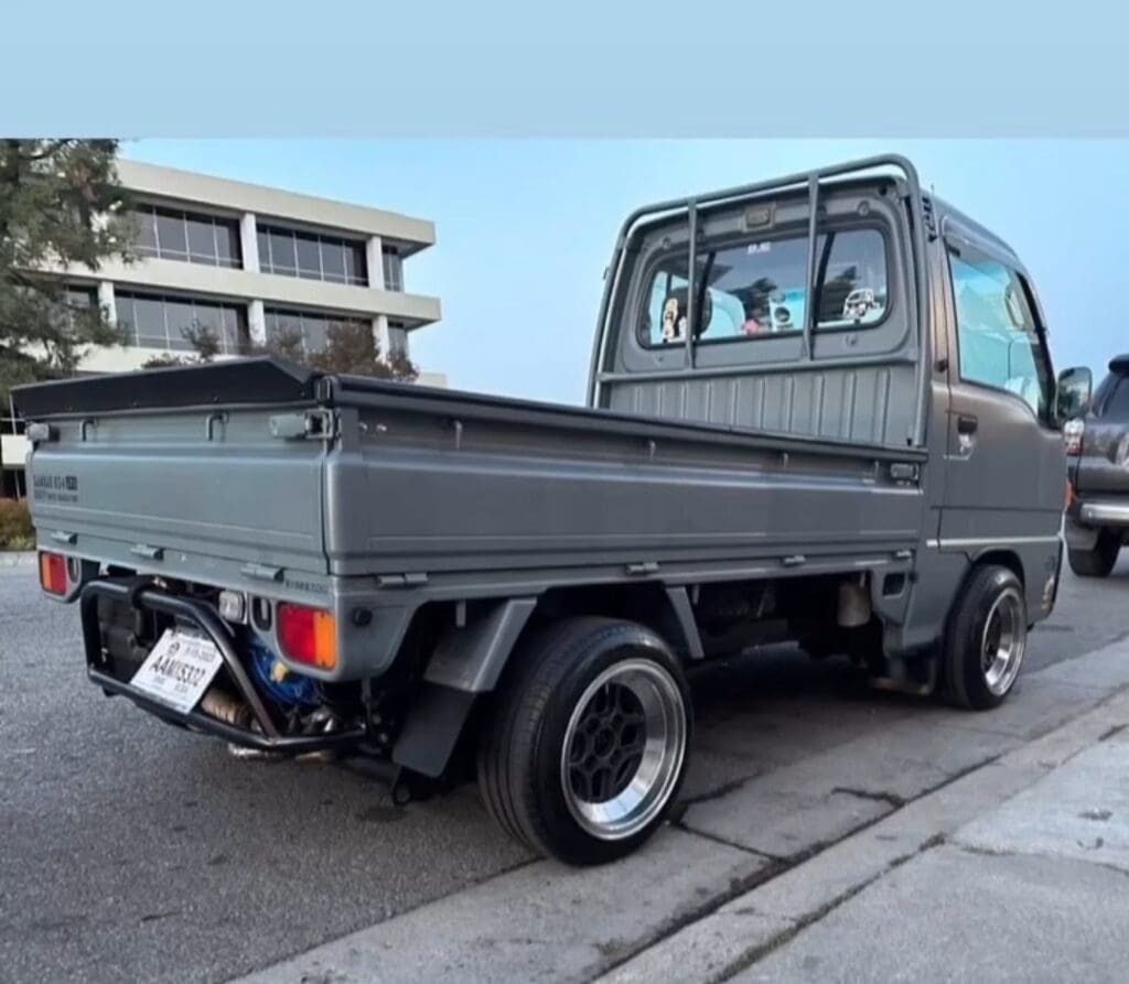 Compact black pickup truck parked on a street.