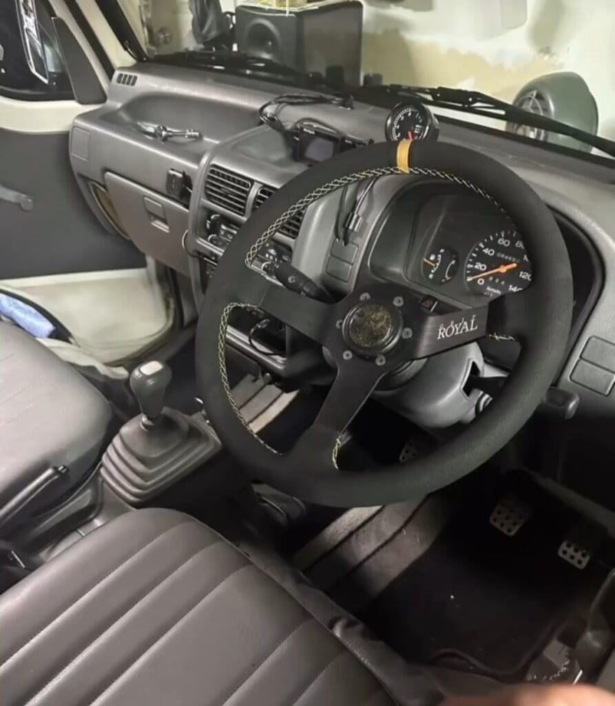Interior of a vehicle showing the steering wheel and dashboard.