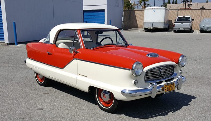 Classic red and white vintage car parked outdoors.