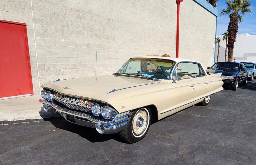 Classic cream-colored Cadillac parked outdoors on a sunny day.