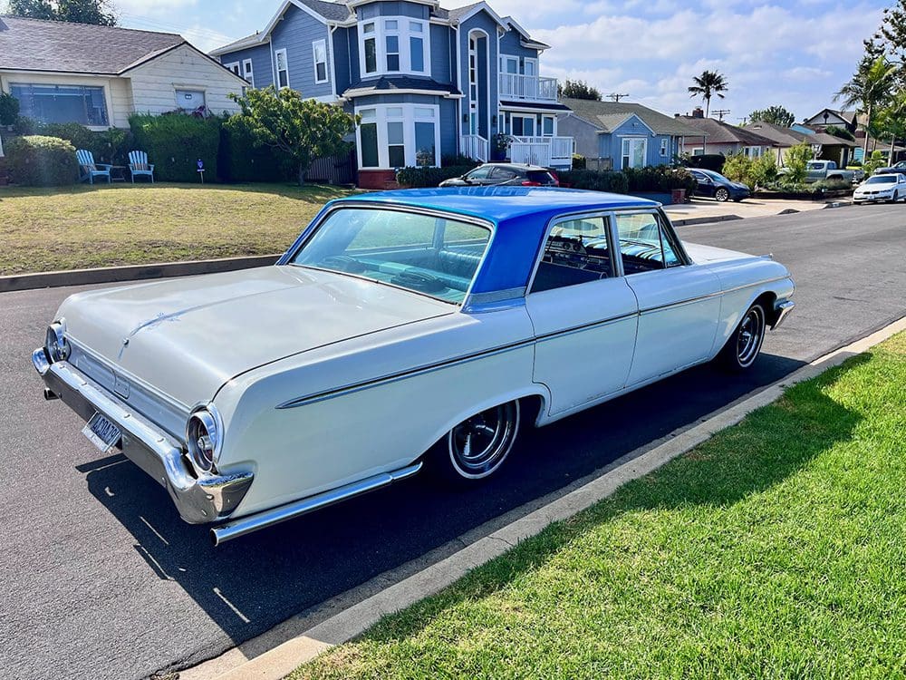 Classic white vintage car parked on a suburban street.