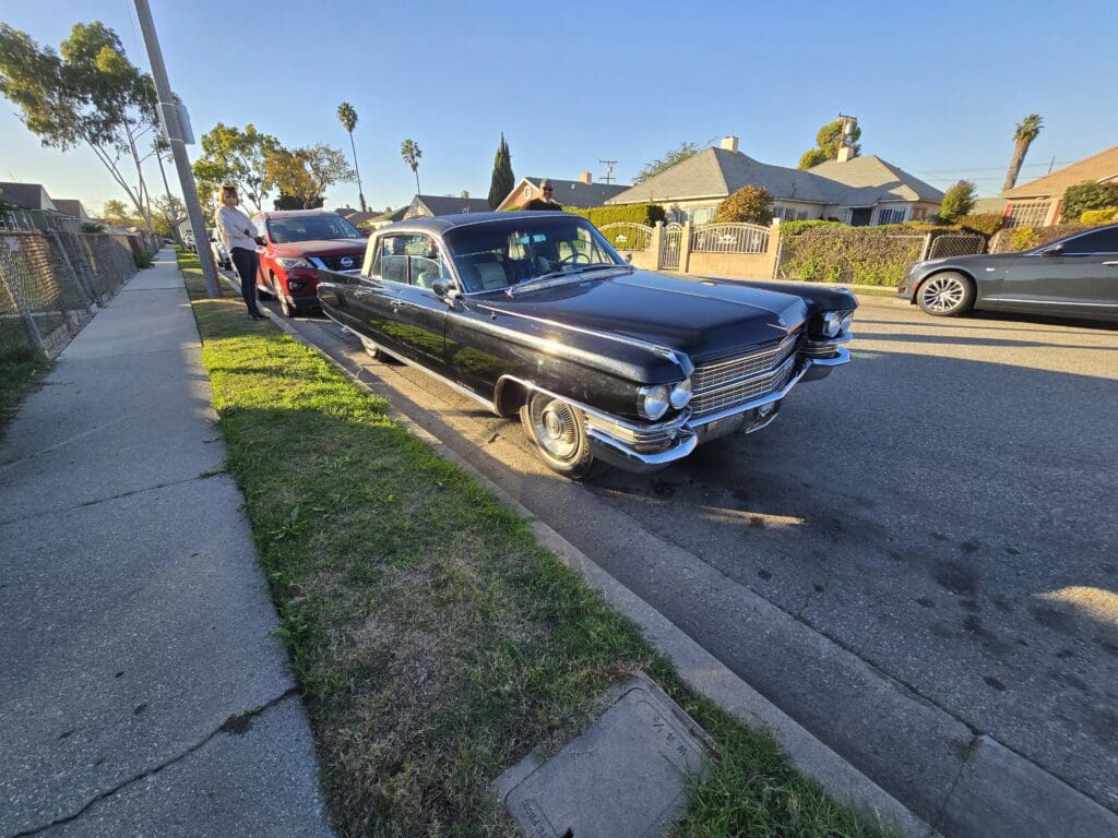 Classic black vintage car parked on a suburban street.