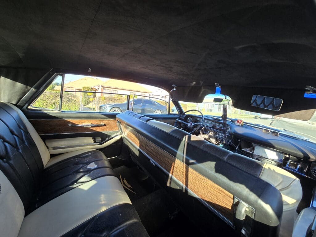 Interior of a vintage car with a wooden dashboard and classic design.