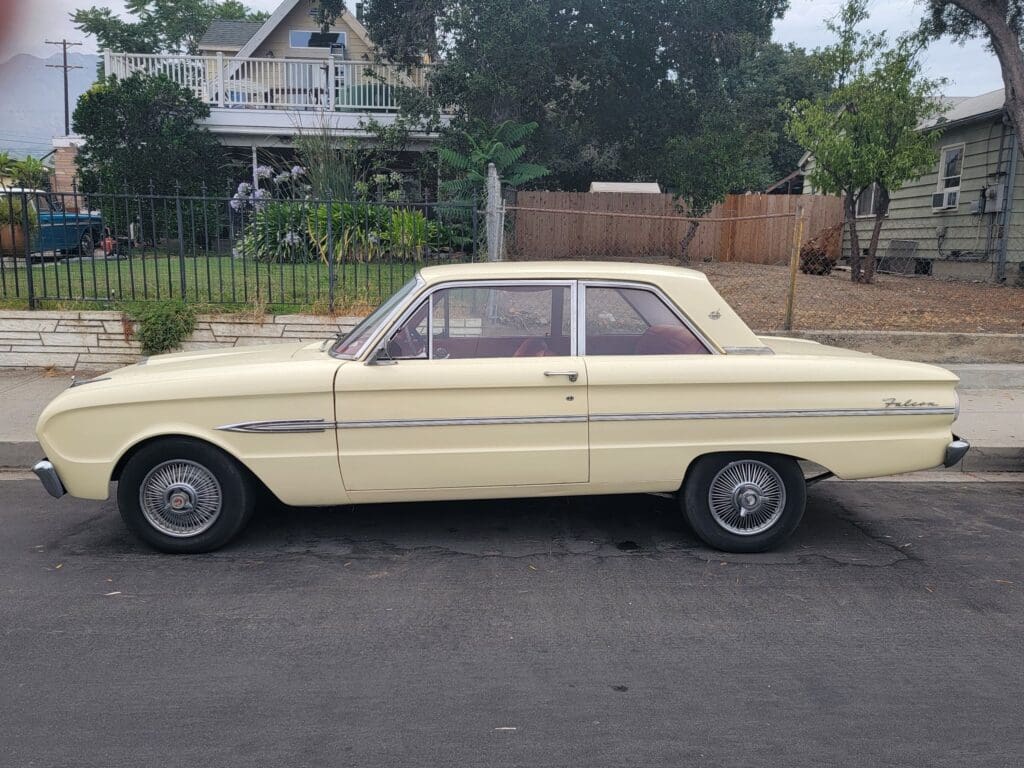 Classic beige vintage car parked on a suburban street.