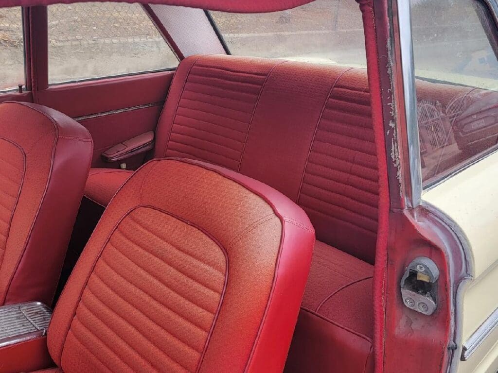 Vintage red car interior with leather seats and classic design.