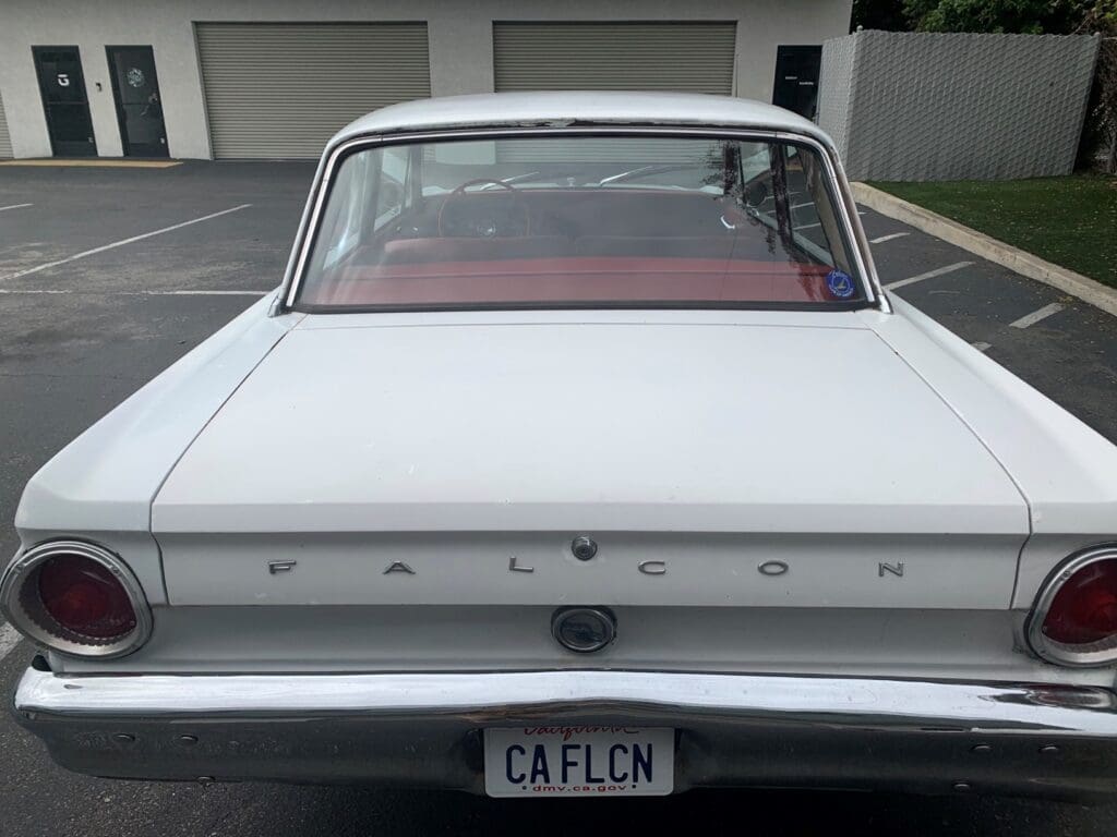 Classic white vintage car parked on a street.