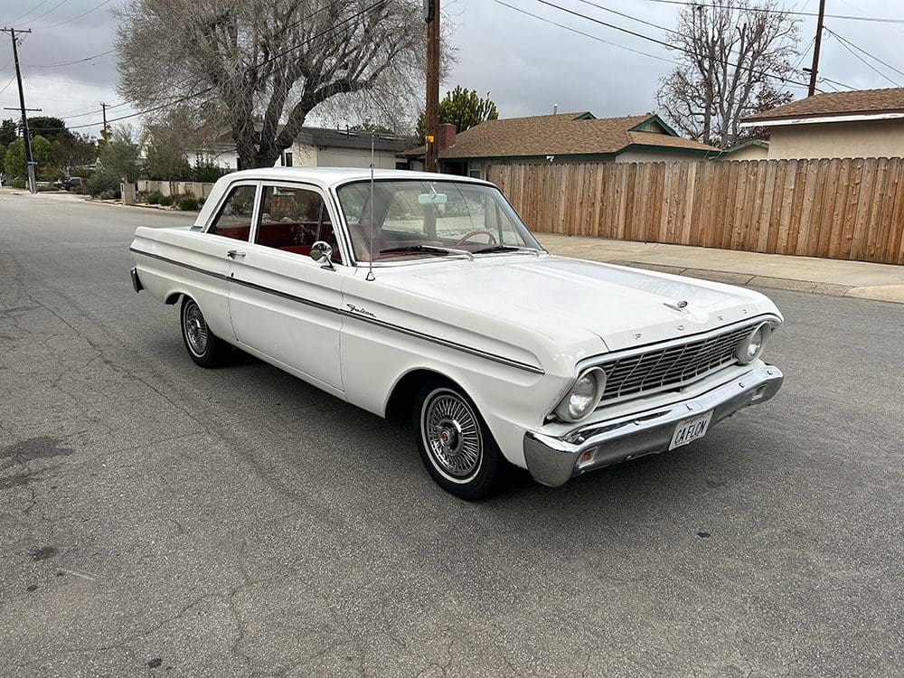 Classic white vintage car parked on a suburban street.