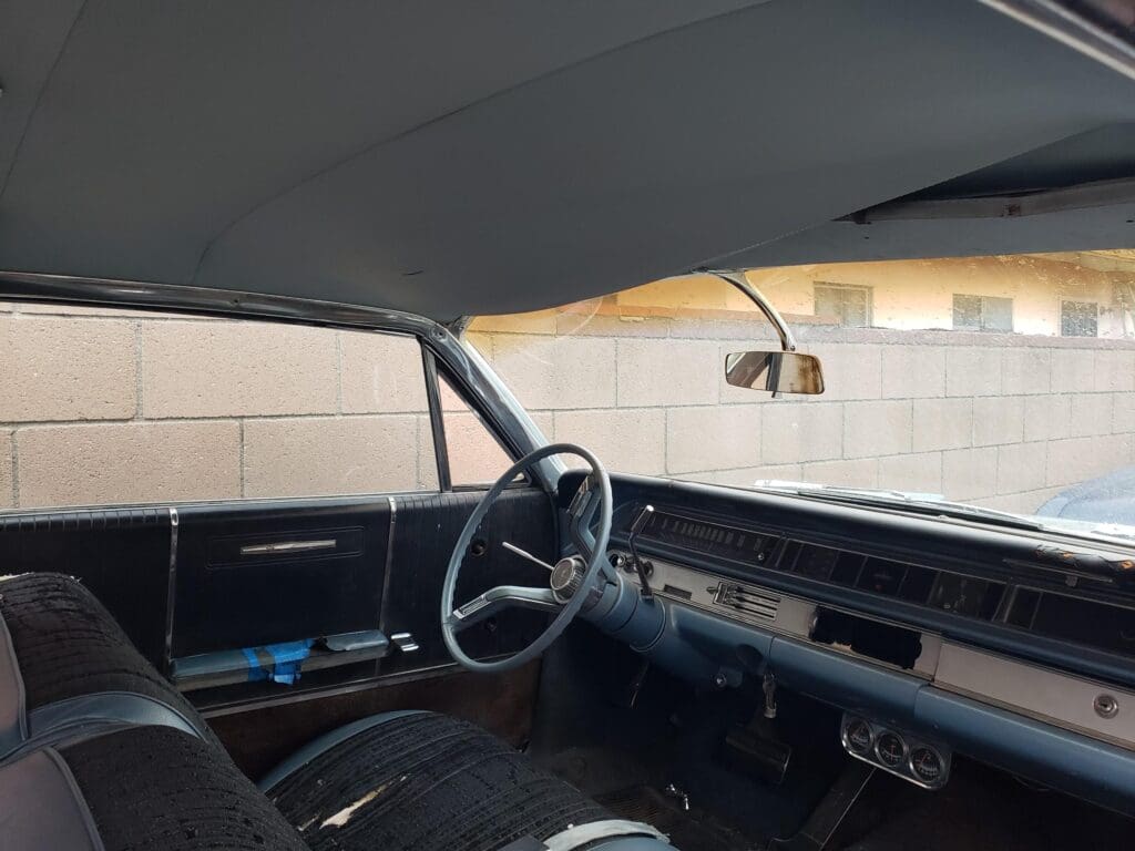 Interior of a vintage car showing dashboard and steering wheel.