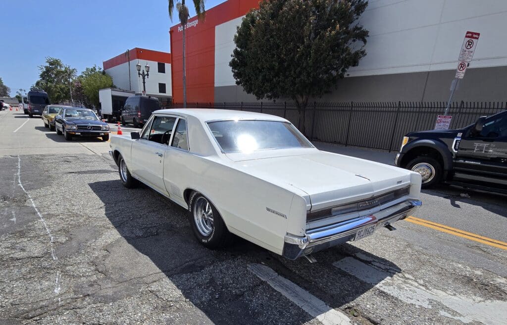 Classic white vintage car parked on a sunny street.