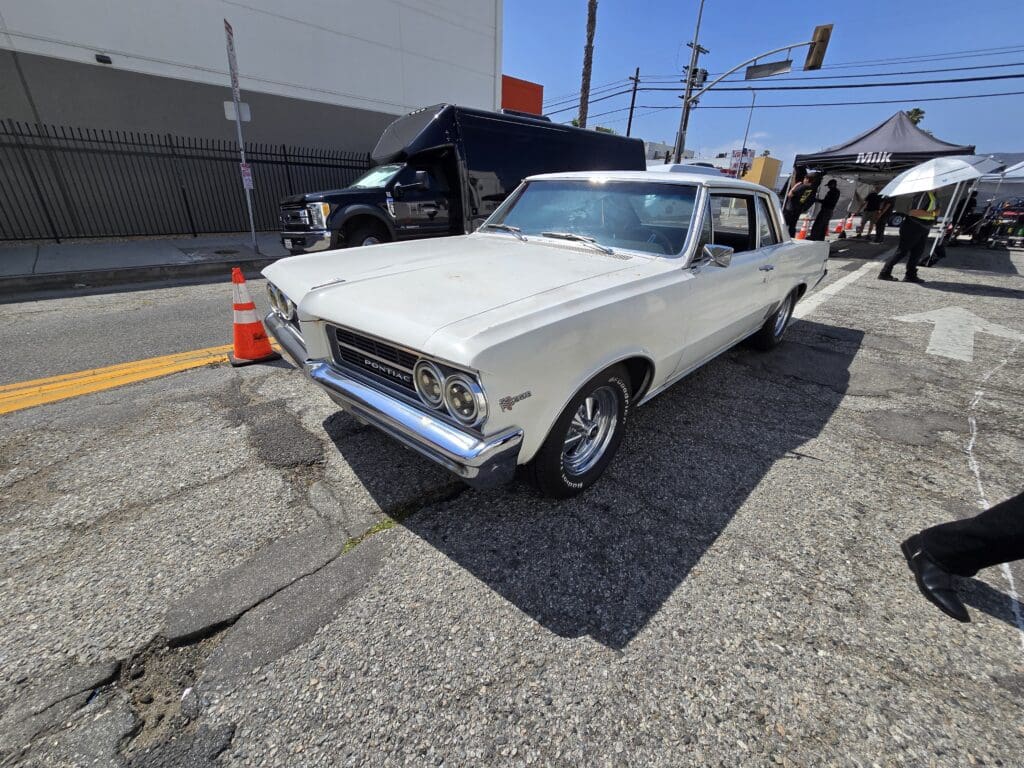 Classic white muscle car parked on a sunny street.