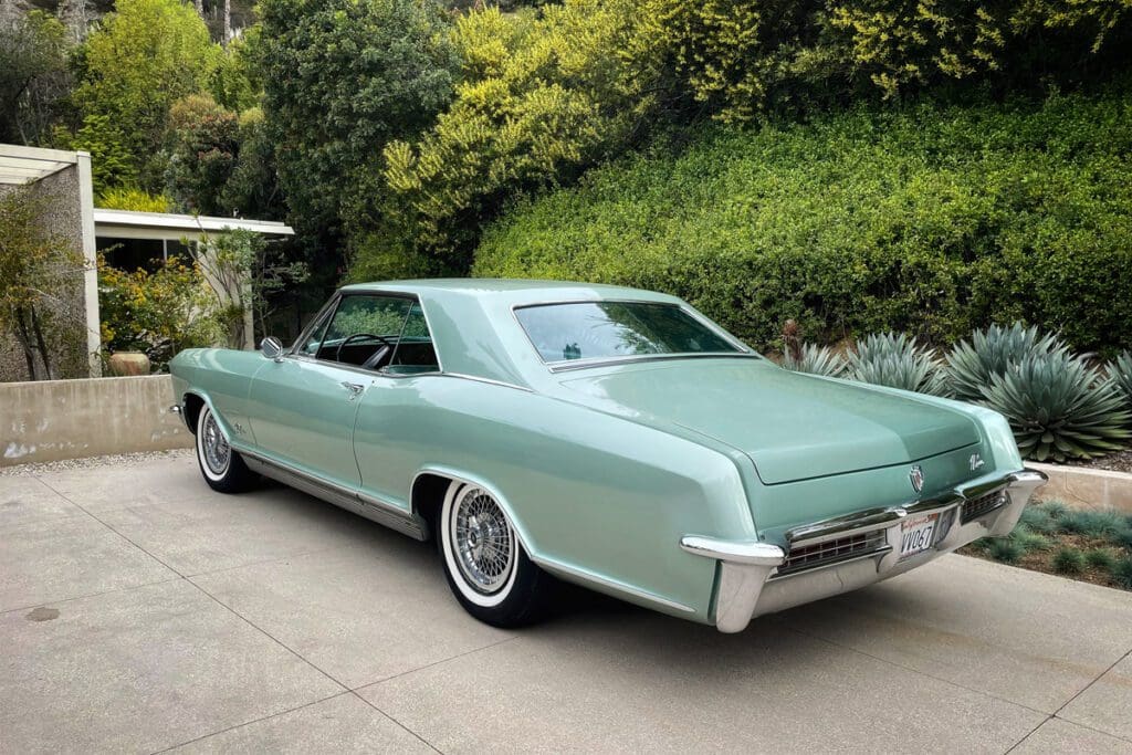 A vintage green classic car parked outdoors.