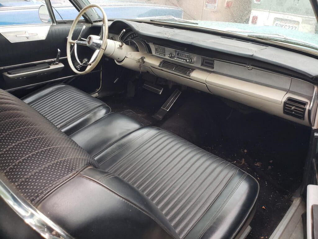 Interior of a classic car with black leather seats and dashboard.