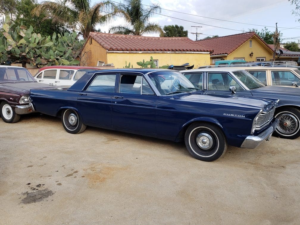 Classic dark blue vintage car parked outdoors.