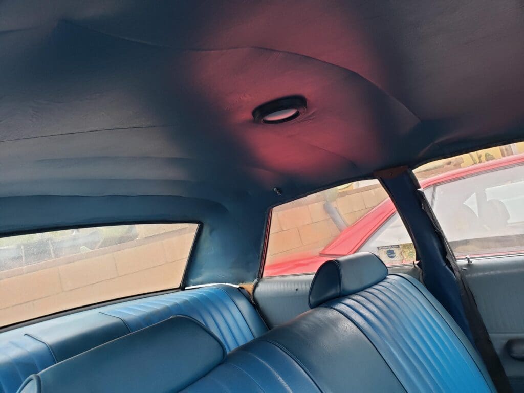 Interior view of a car's backseat with leather seats and a window.