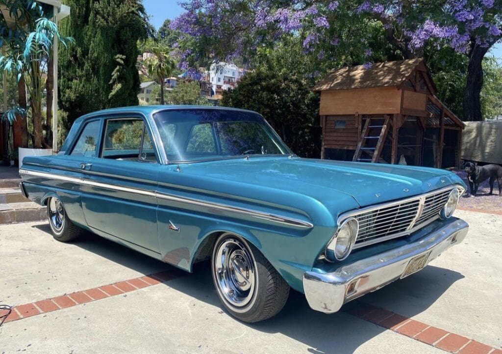 Classic blue vintage car parked on a sunny street.
