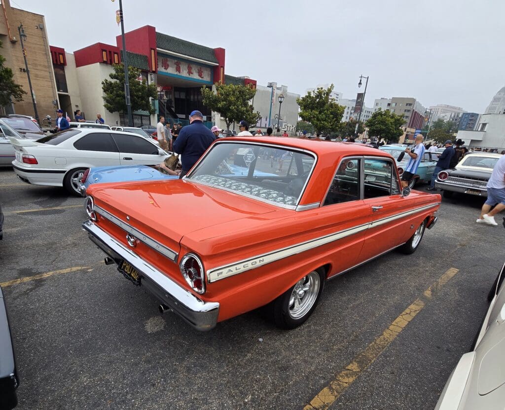 Classic orange vintage car parked at a car show.
