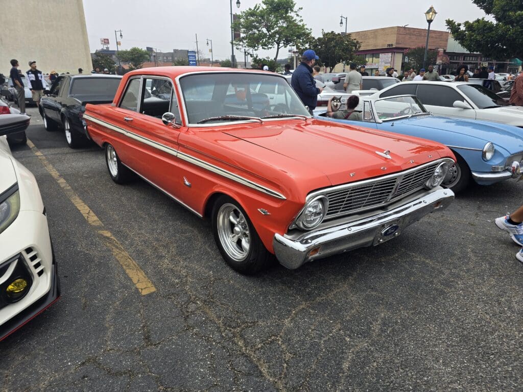 Classic red vintage car parked at an outdoor event.