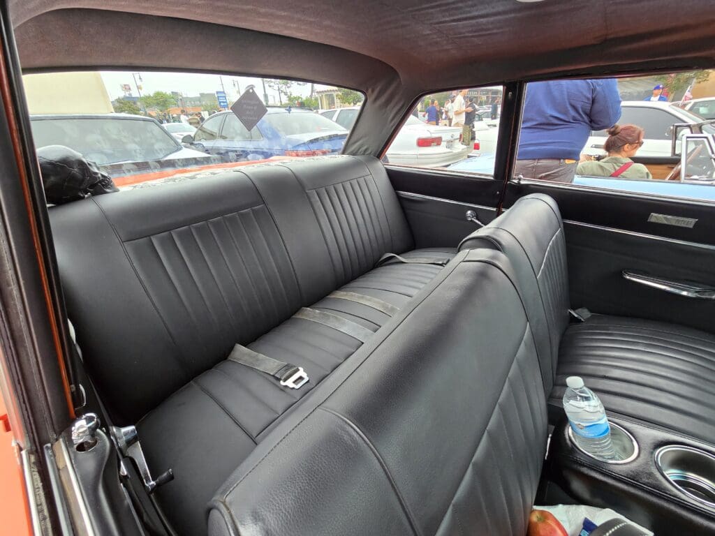 Interior view of a car with black leather seats and seat belts.