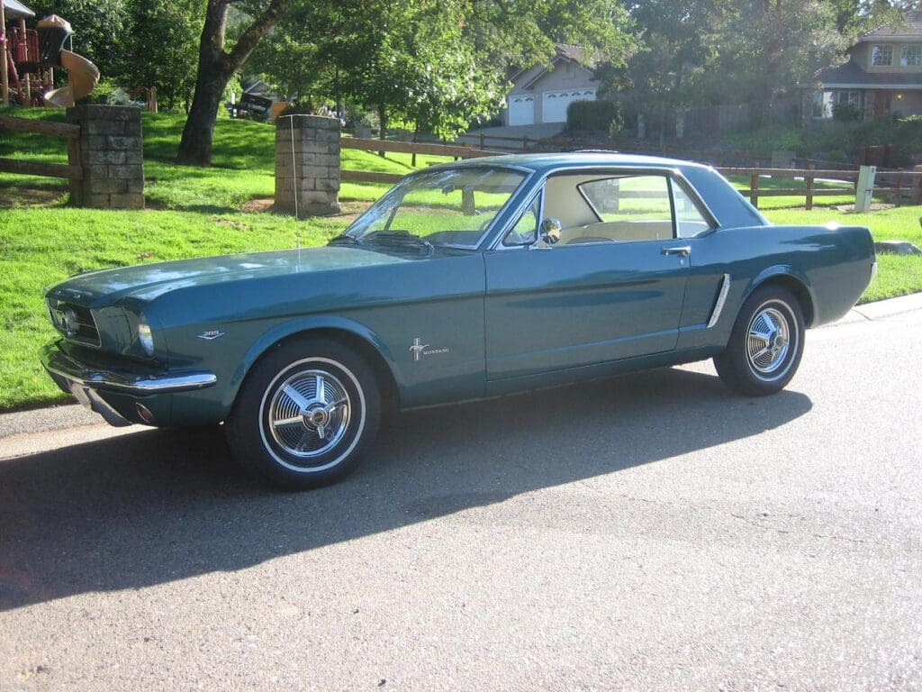 Classic blue Ford Mustang parked on a sunny street.