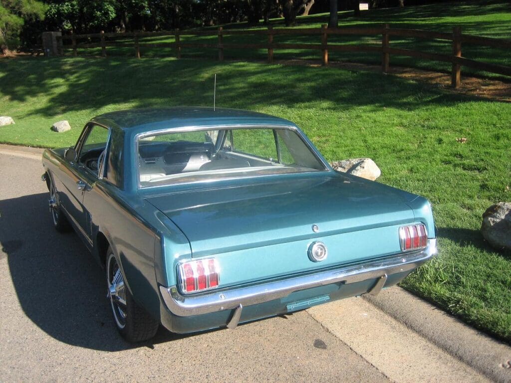 Classic blue Ford Mustang parked on a sunny street.