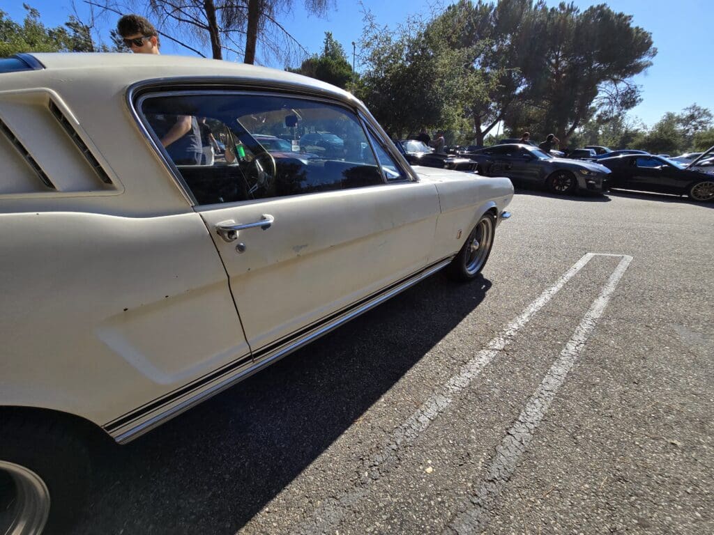 Classic white Ford Mustang parked on a sunny day.