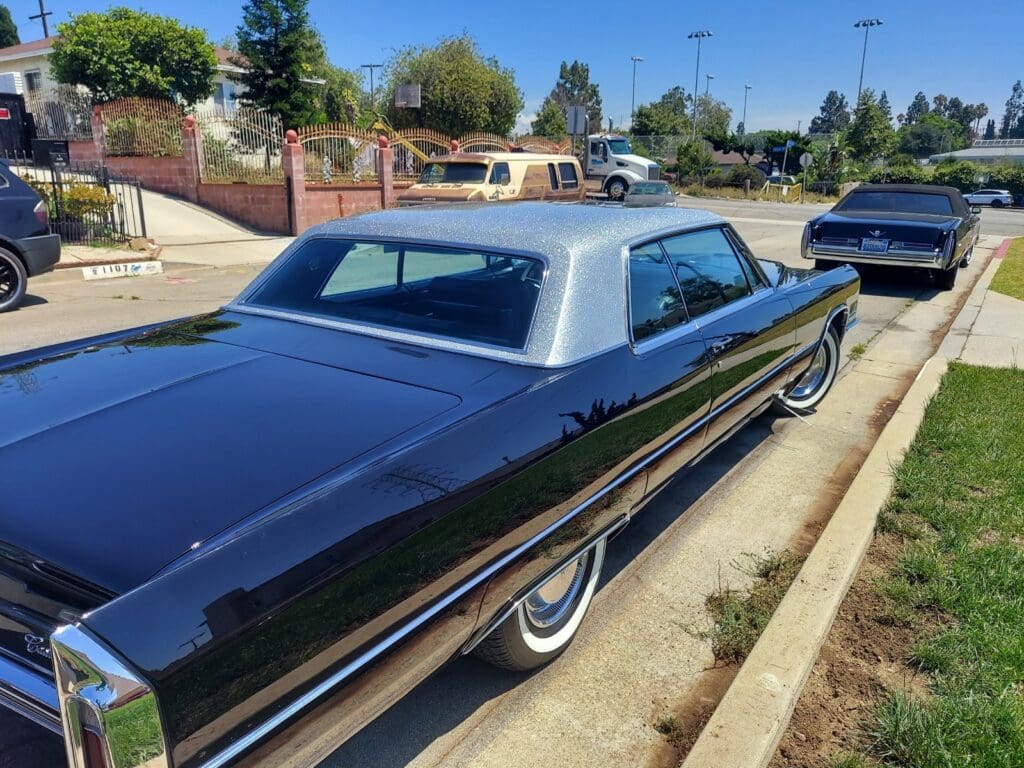 Classic black vintage car parked on a sunny street.