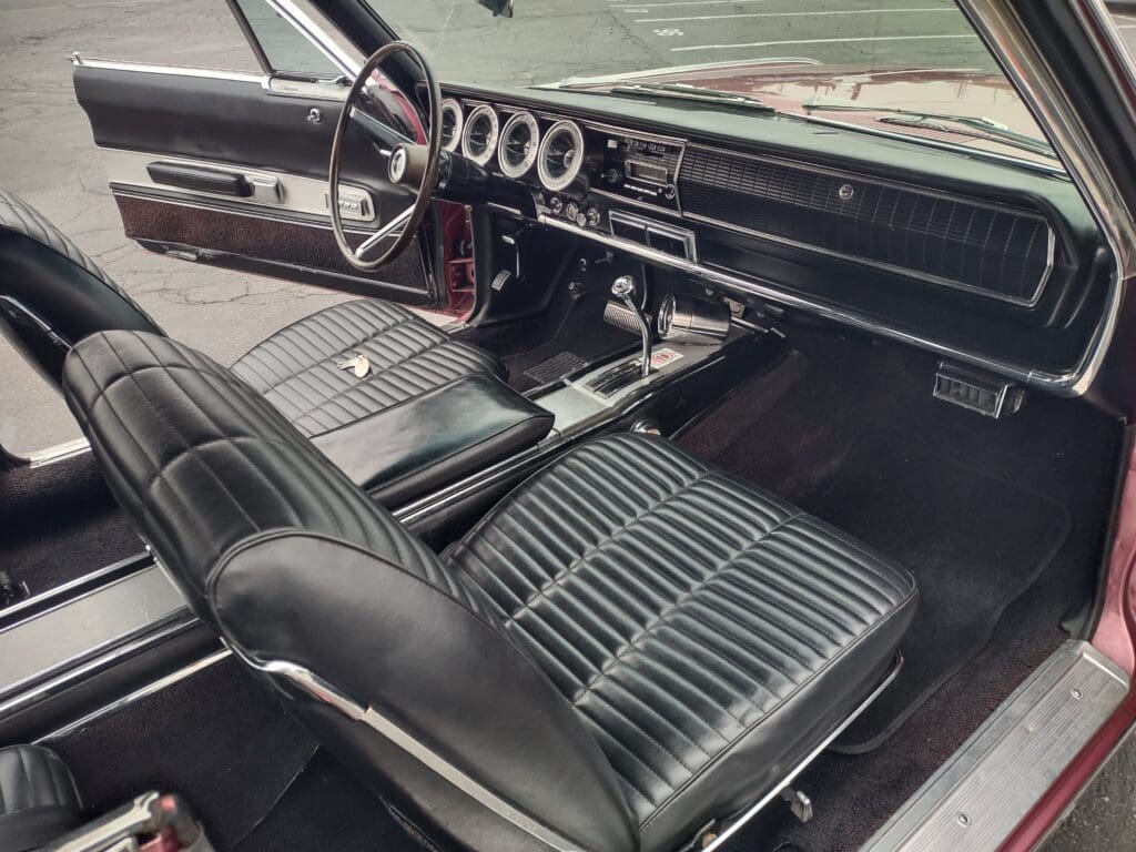 Classic car interior with black leather seats and vintage dashboard.