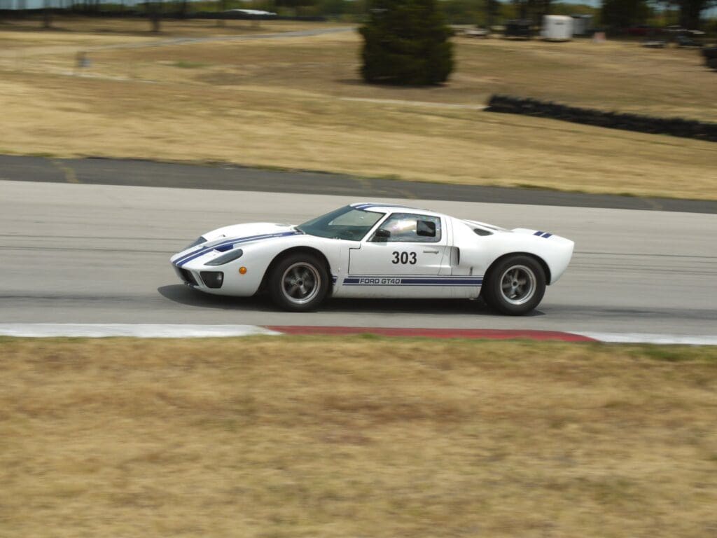 White sports car racing on a track with number 381.