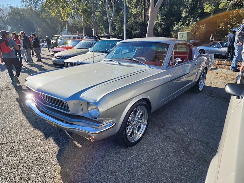 Classic silver Ford Mustang parked outdoors on a sunny day.