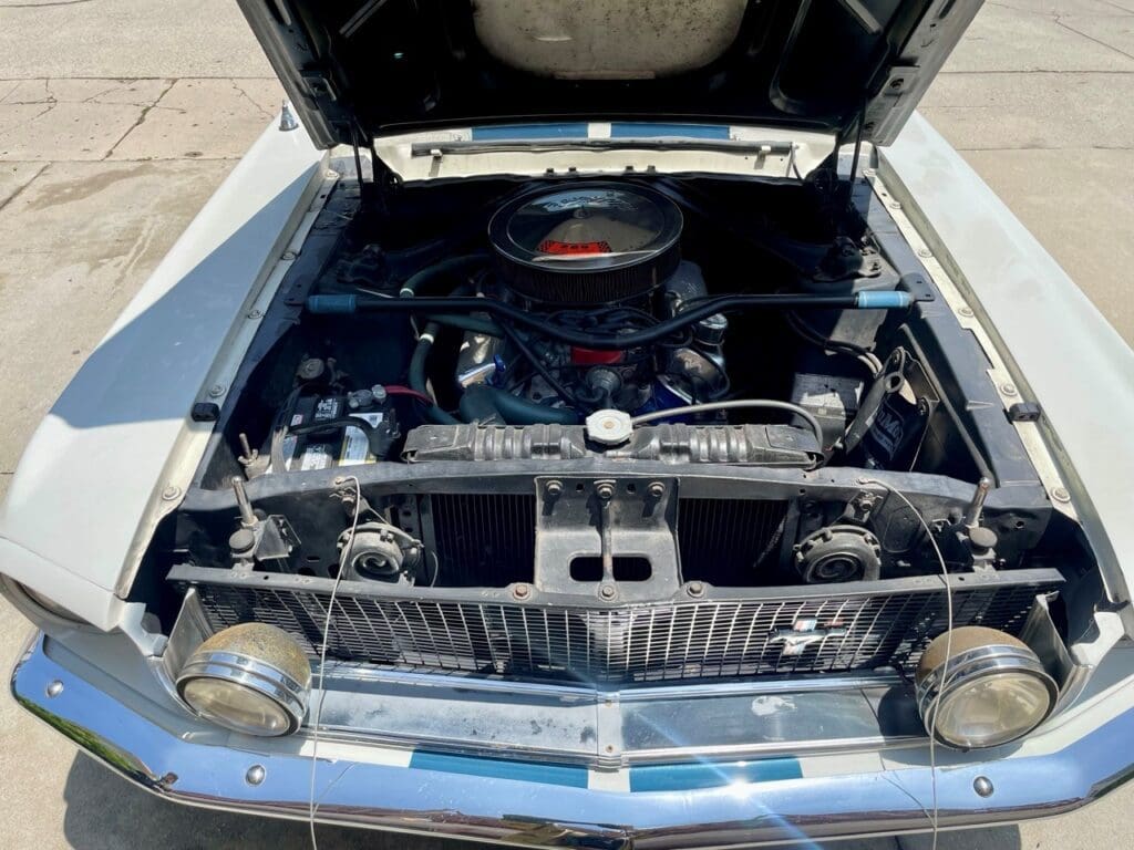 Classic car engine bay with a polished air cleaner and chrome details.
