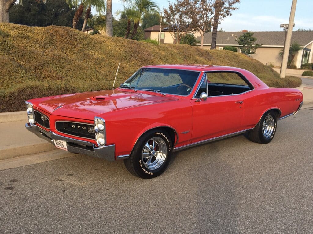 Classic red muscle car parked on a suburban street.