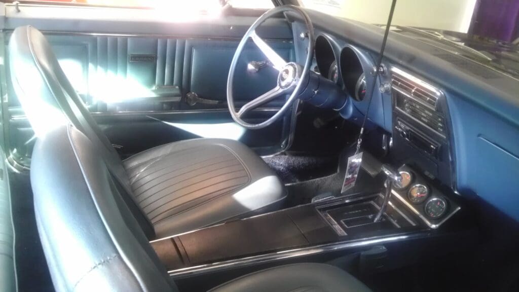 Interior of a vintage car showcasing a classic steering wheel and leather seats.