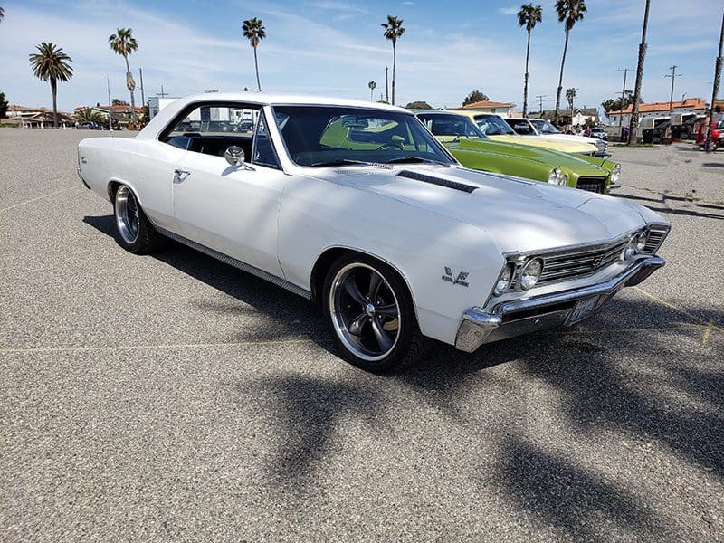 Classic white muscle car parked outdoors on a sunny day.