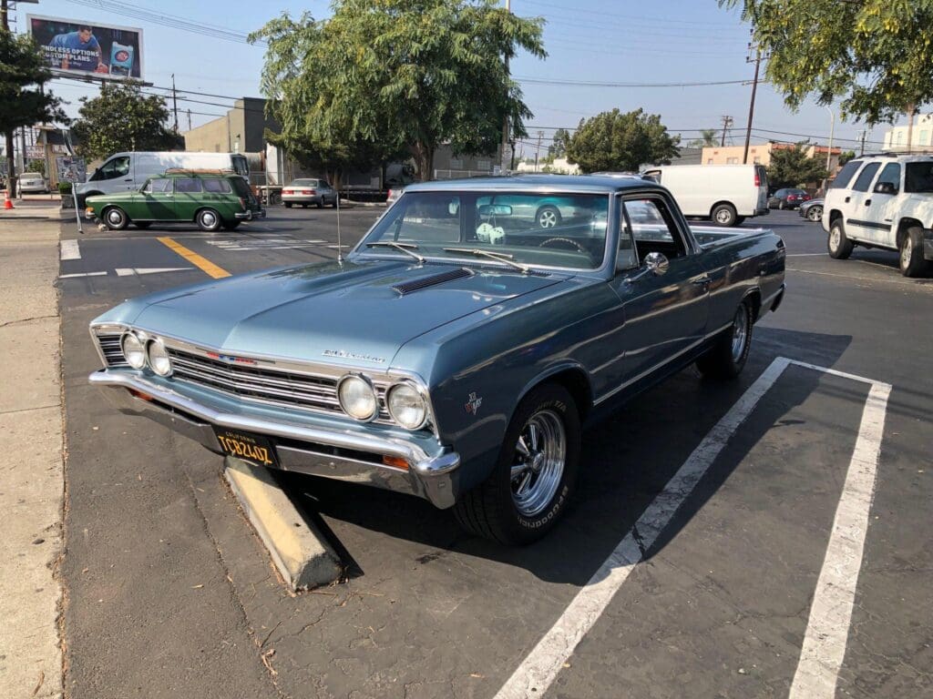 Classic blue convertible car parked in a lot on a sunny day.