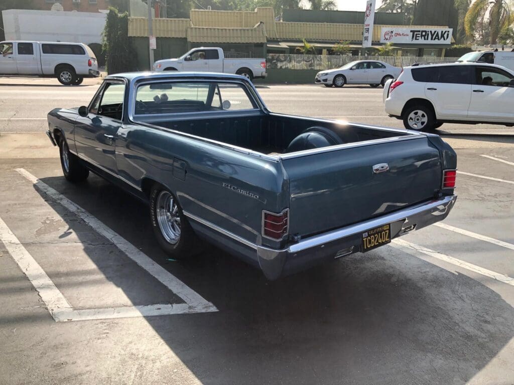 Classic blue pickup truck parked in a lot.