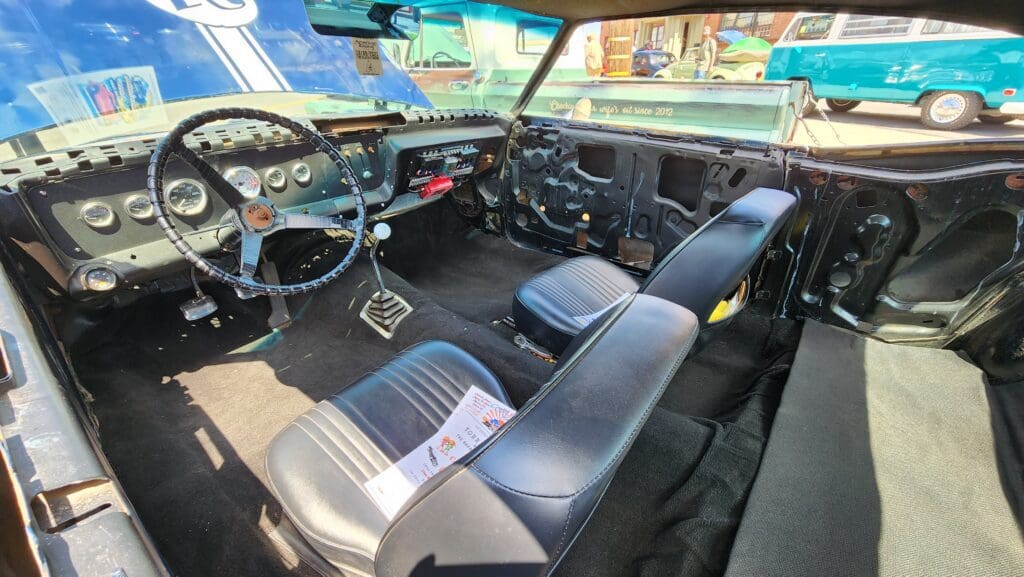 Interior of a vintage car with sporty seats and a manual transmission.