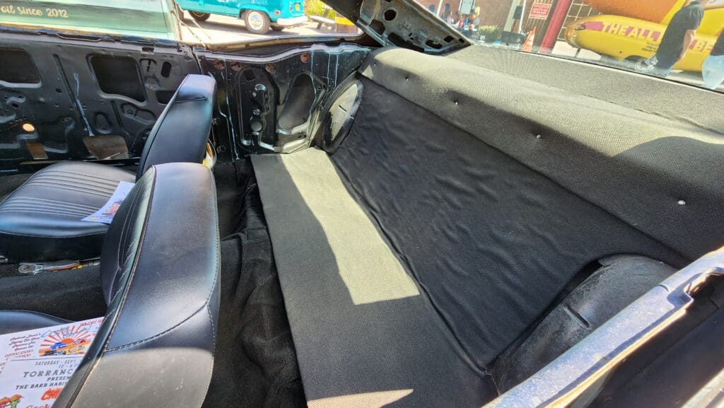 Rear interior of a car with black upholstery and carpet.