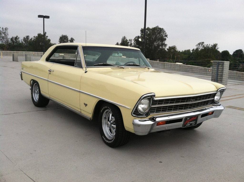 Classic yellow 1960s Chevrolet Nova parked outdoors.