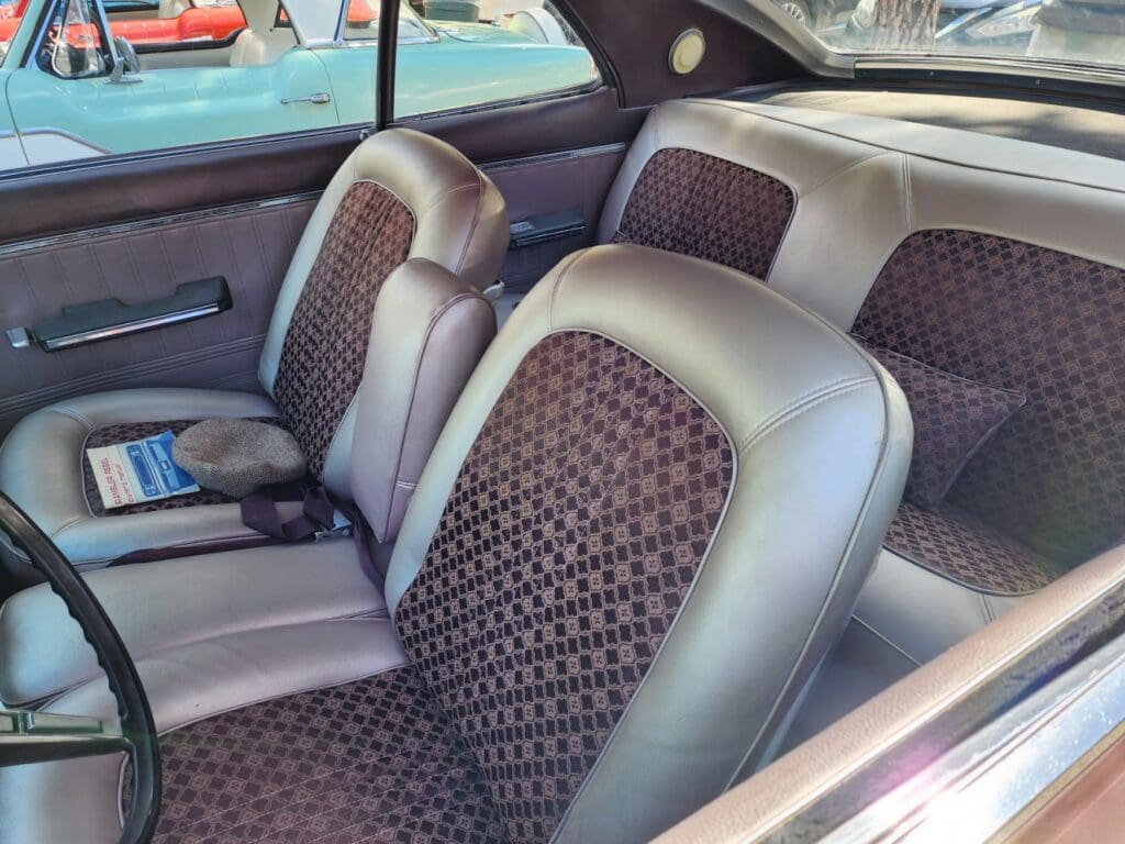 Interior of a vintage car with patterned fabric seats.