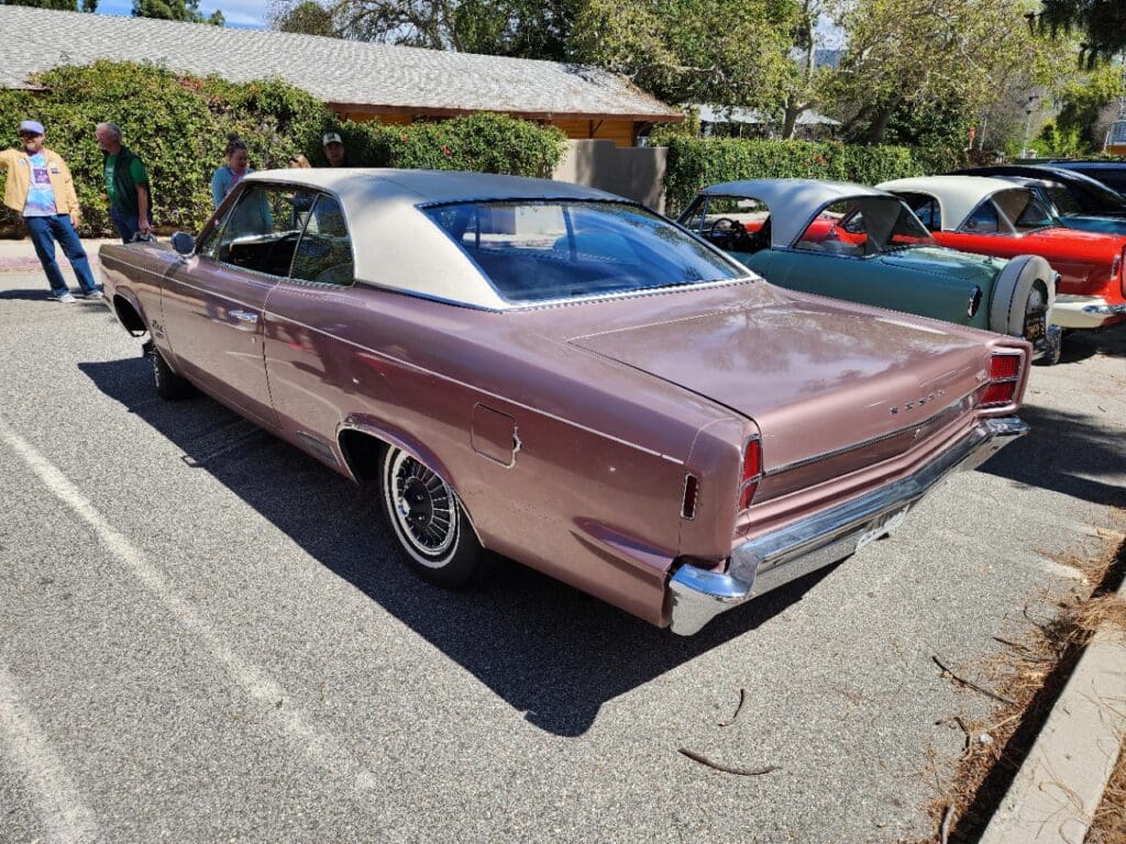 Classic purple convertible car parked outdoors on a sunny day.