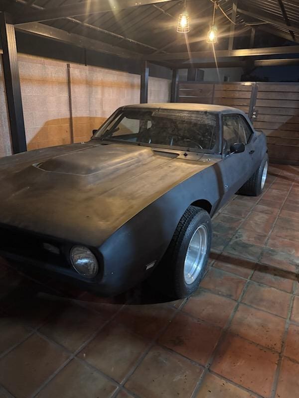 Classic muscle car in a dimly lit garage.