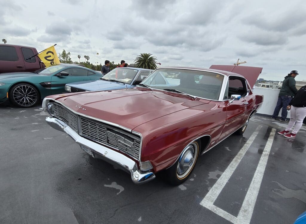 Classic red vintage car parked on a cloudy day.