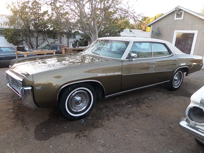 Classic vintage car parked outdoors on a dirt surface.