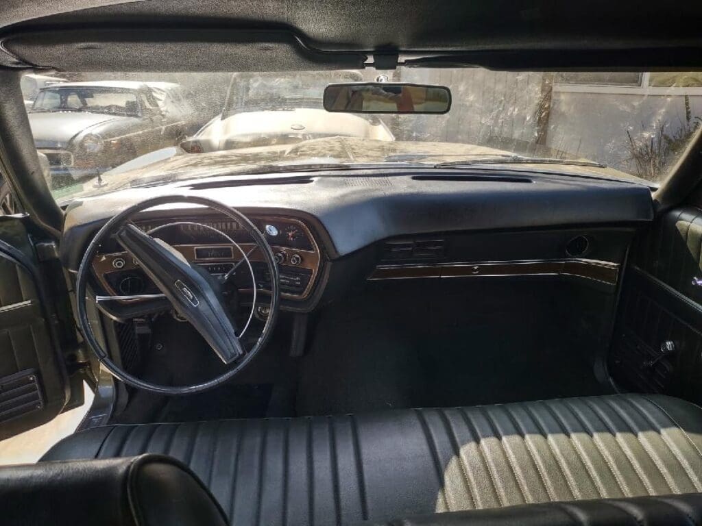 Interior of a vintage car with a classic steering wheel and dashboard.
