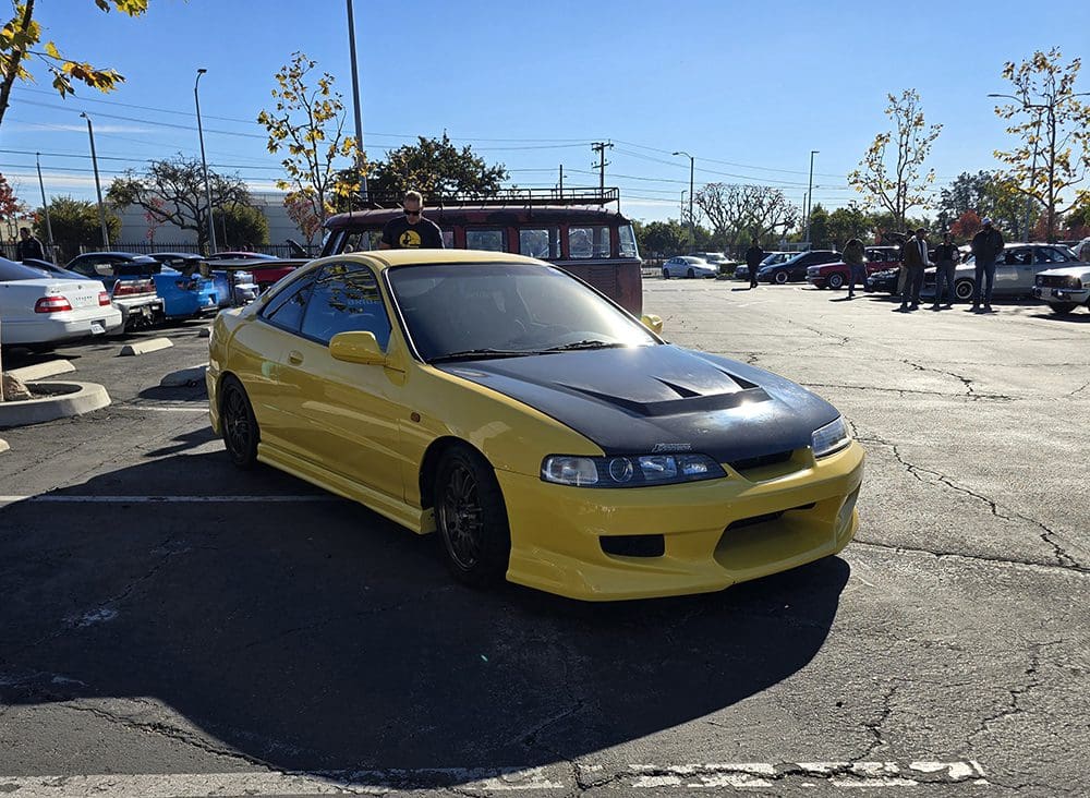 Yellow sports car parked in a sunny lot.