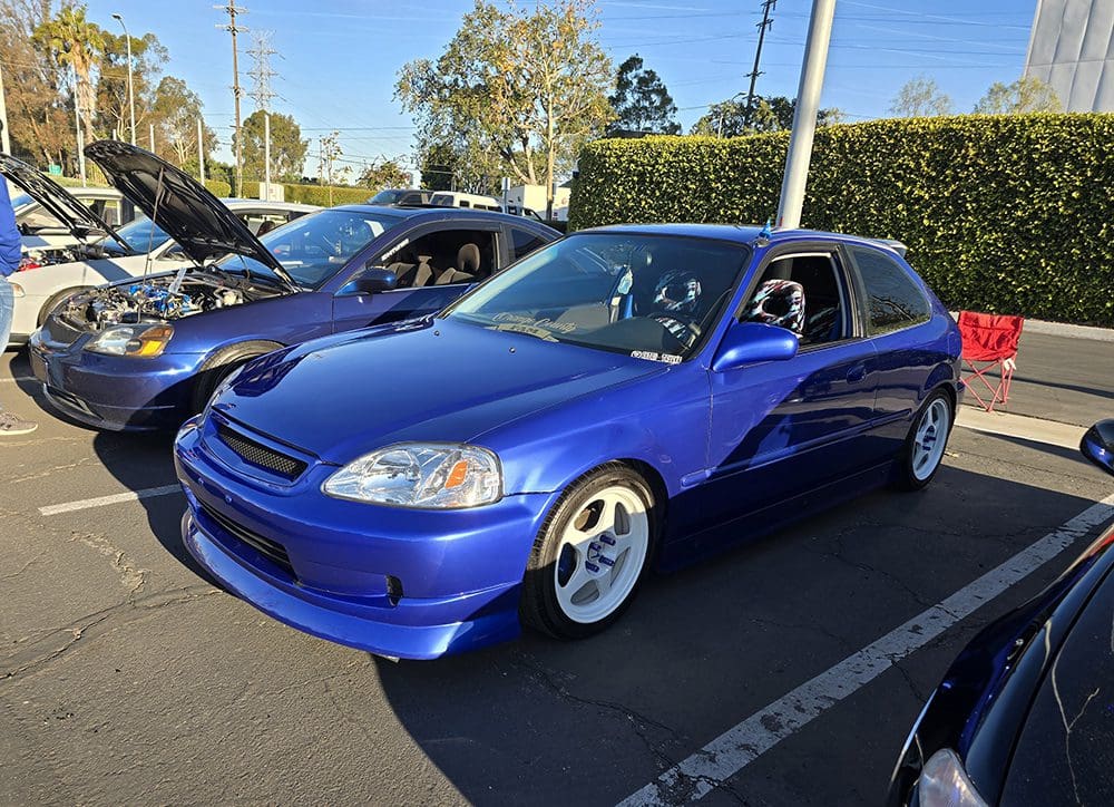 Blue Honda Civic parked at a car meet with custom wheels.