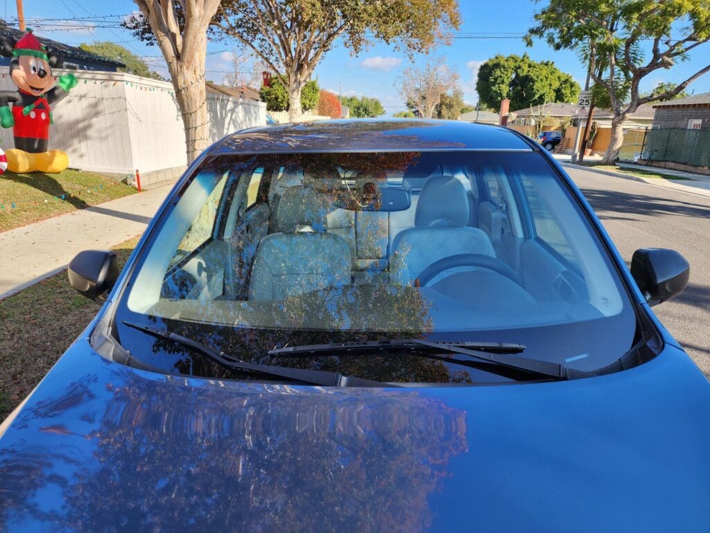 Car windshield damaged with visible spiderweb cracks.