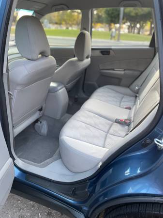 Clean and spacious rear seat of a car with light upholstery.