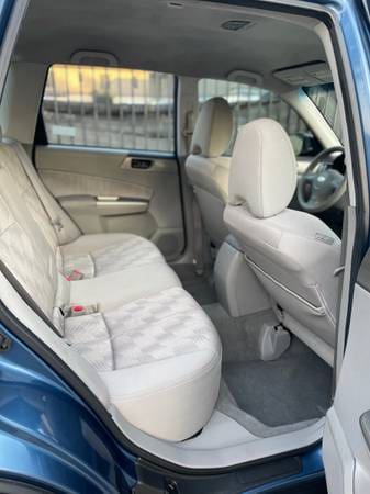 Clean, spacious rear seats of a modern car with light upholstery.