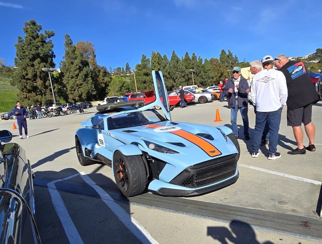 A blue custom sports car with racing stripes on display.